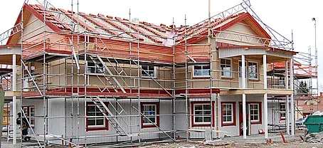 Villa under uppförande med ställning kring det röda taket.