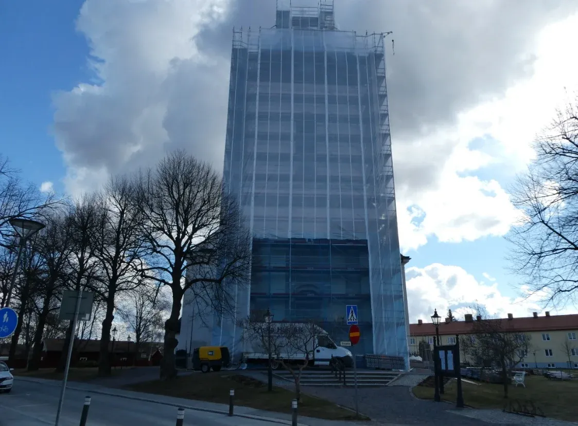 Kyrktornet i ställning sett på håll från vägen.