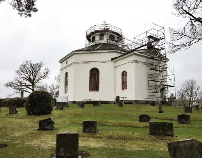 Kyrka omgärdad av byggnadsställning under renovering.