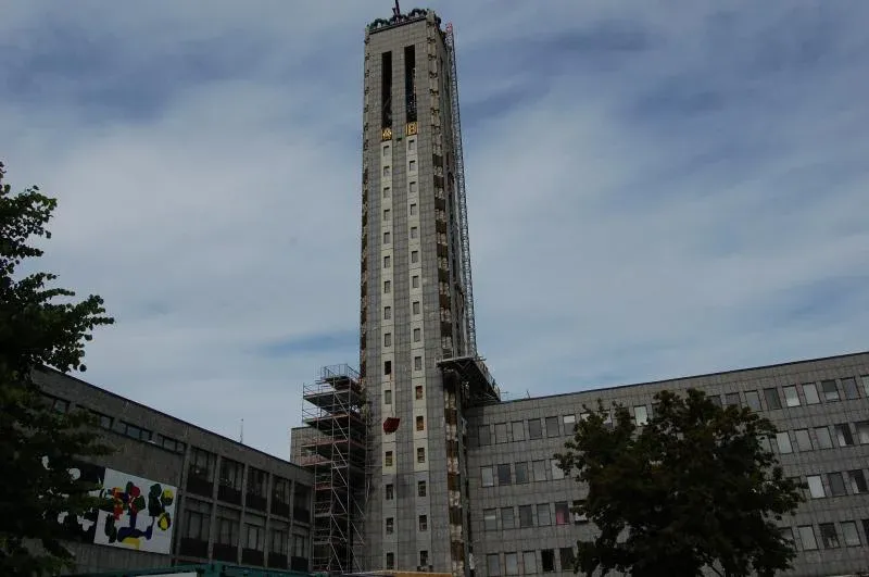 Högt betongtorn med ställning längs fasaden.